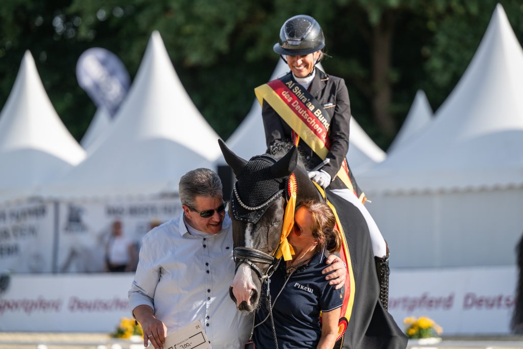 So sieht ein geliebtes Kind aus: Bundeschampion Soxx mit seinen Züchtern und Besitzern Simon Kohlenbrenner und Nicole Plaster. Foto: Vortmann
